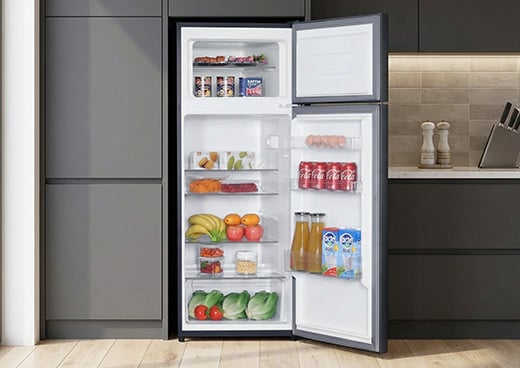 Otwarta lodówka z zamrażalnikiem górnym Total No Frost MPM-206-CZ-49/D wypełniona produktami spożywczymi stoi w kuchni.