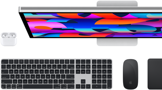 Widok z góry na monitor Studio Display, klawiaturę Magic Keyboard w kolorze czarnym, mysz Magic Mouse w kolorze czarnym, gładzik Magic Trackpad w kolorze czarnym i etui do AirPods w kolorze białym