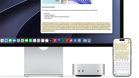 Widok z przodu na Maca mini schowanego pod monitorem Studio Display, po prawej stronie urządzenia i monitora znajduje się iPhone; na iPhonie widać zaznaczony tekst z poleceniami wcięcia, kopiowania, wklejania i automatycznego wstawiania powyżej, który odpowiada wyróżnionemu tekstowi na wyświetlaczu, co demonstruje działanie Uniwersalnego schowka