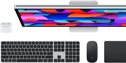Zestaw akcesoriów i urządzeń, w tym AirPods, klawiatura Magic Keyboard z Touch ID, mysz Magic Mouse, gładzik Magic Trackpad, monitor Studio Display