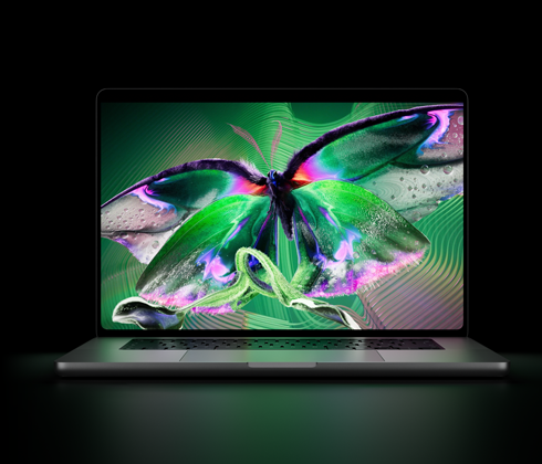 Otwarty MacBook Pro z wyświetlaczem PROLED XDR, kolor srebrny, ekran ukazuje bogate w detale zdjęcie o wysokim kontraście i żywych kolorach, a jego światło oświetla klawiaturę
