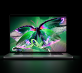 Otwarty MacBook Pro z wyświetlaczem PROLED XDR, kolor srebrny, ekran ukazuje bogate w detale zdjęcie o wysokim kontraście i żywych kolorach, a jego światło oświetla klawiaturę