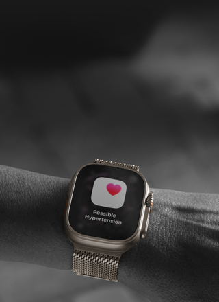Osoba nosząca na nadgarstku Apple Watch Ultra 3, widać ekran z powiadomieniem o możliwym nadciśnieniu