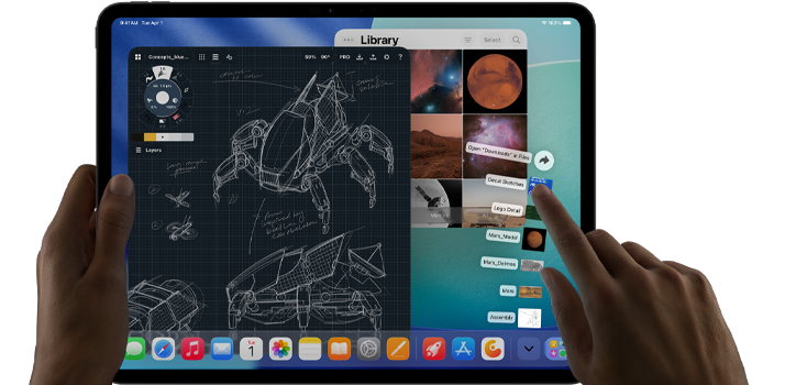 iPad Pro w kolorze gwiezdnej czerni, lewa ręka trzyma urządzenie, prawa ręka obsługuje gestami wiele otwartych okien aplikacji, na ekranie aplikacja do rysowania ze szkicami konstrukcji mechanicznych, biblioteka zdjęć z planetami i obrazami kosmosu oraz folder z rozstawionymi wachlarzowo pobranymi plikami