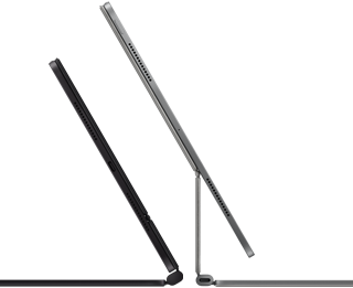 Dwa widoczne z boku smukłe iPady Pro podłączone do klawiatur Magic Keyboard, jednej w kolorze gwiezdnej czerni, nachylonej i półotwartej, z głośnikami i portem USB‑C, i drugiej w kolorze srebrnym, otwartej i nachylonej tak, że widać konstrukcję wspornika, głośników i mikrofonu