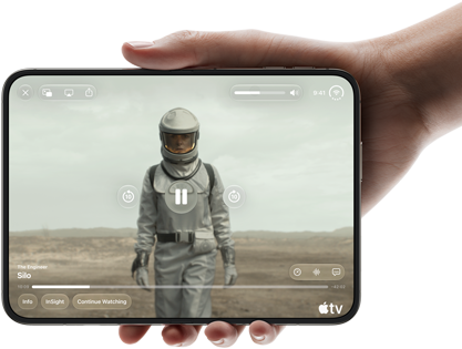 Całkowicie rozłożony iPhone Duo trzymany w jednej dłoni w pozycji poziomej, na wyświetlaczu wewnętrznym widać serial „Silos” w apce Apple TV