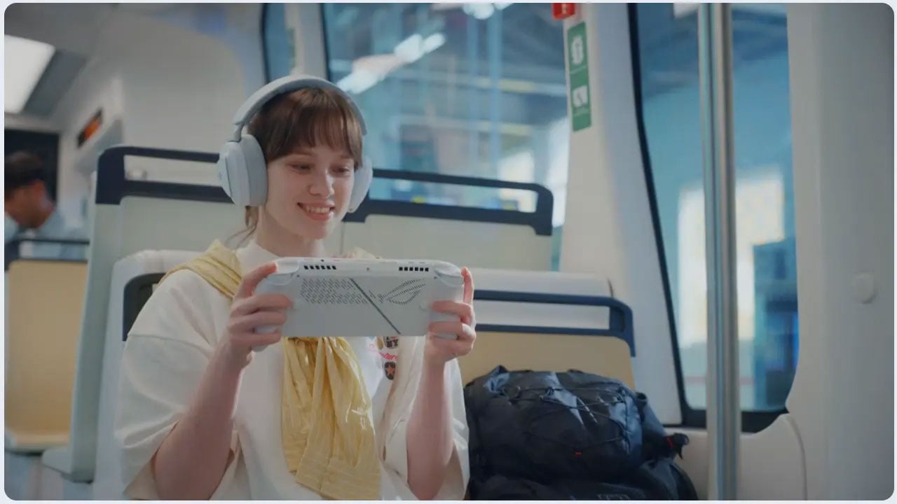 Na zdjęciu widać uśmiechniętą osobę, która siedzi w pociągu, ma słuchawki na uszach i gra na ROG Xbox Ally.