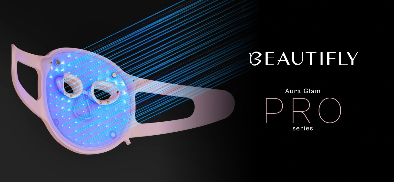 Różowa maska do terapii światłem LED na twarz Beautifly Aura Glam Pro na czarnym tle z niebieskimi liniami światła przebiegającymi przez całą powierzchnię maski i jasnym podświetleniem całego panelu