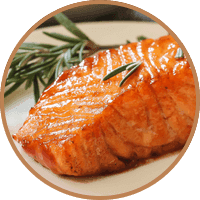 Upieczony filet z łososia w glazurze, na talerzu z gałązką rozmarynu