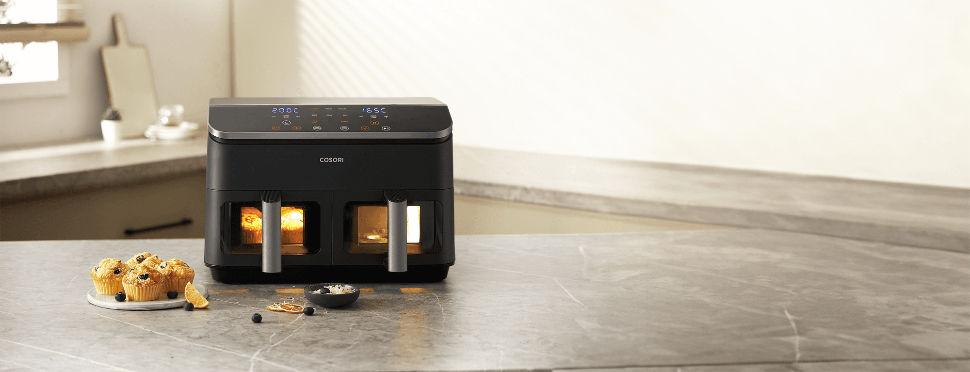 Cosori Dual Basket Airfryer z dwoma podświetlonymi koszami i cyfrowym panelem na tle kuchennego blatu