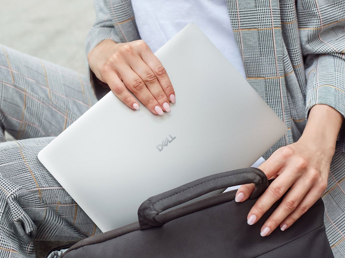 Dell Pro 14 kobieta chowająca laptopa do torby