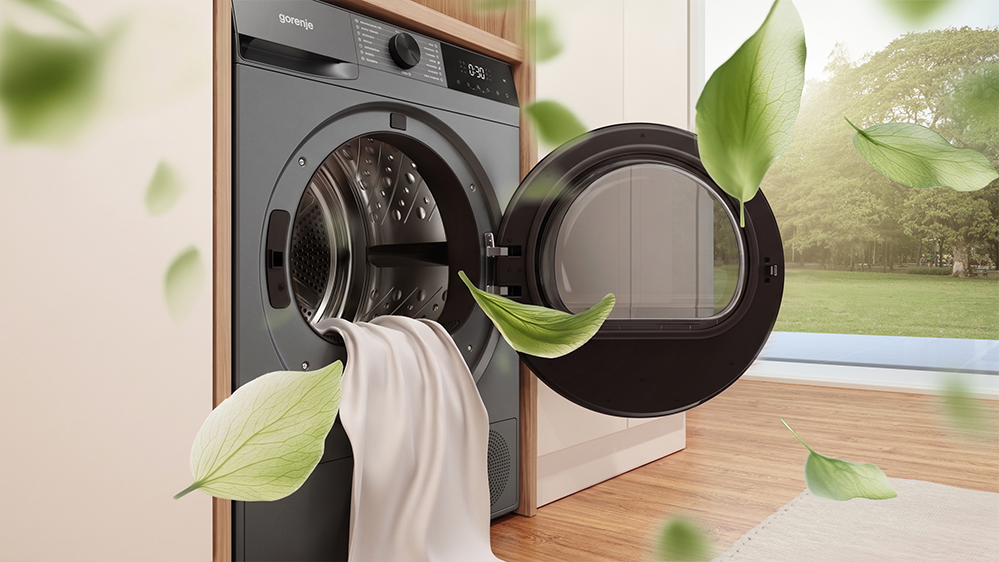 Otwarta czarna suszarka Gorenje z wystającym materiałem oraz unoszącymi się grafikami liści