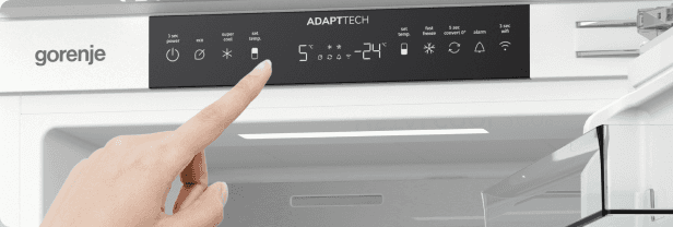 Palec wskazujący na czarny, elektroniczny panel sterowania lodówki marki Gorenje.