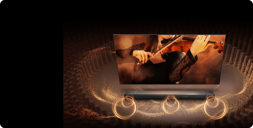 Telewizor z obrazem skrzypaczki i soundbar z napisem ATMOS, z którego rozchodzą się złote okręgi fal dźwiękowych