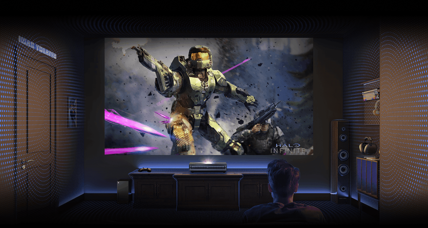 Widok zza gracza na ekran z Master Chiefem z gry Halo Infinite. Cały pokój pokryty siatką niebieskich punktów świetlnych.