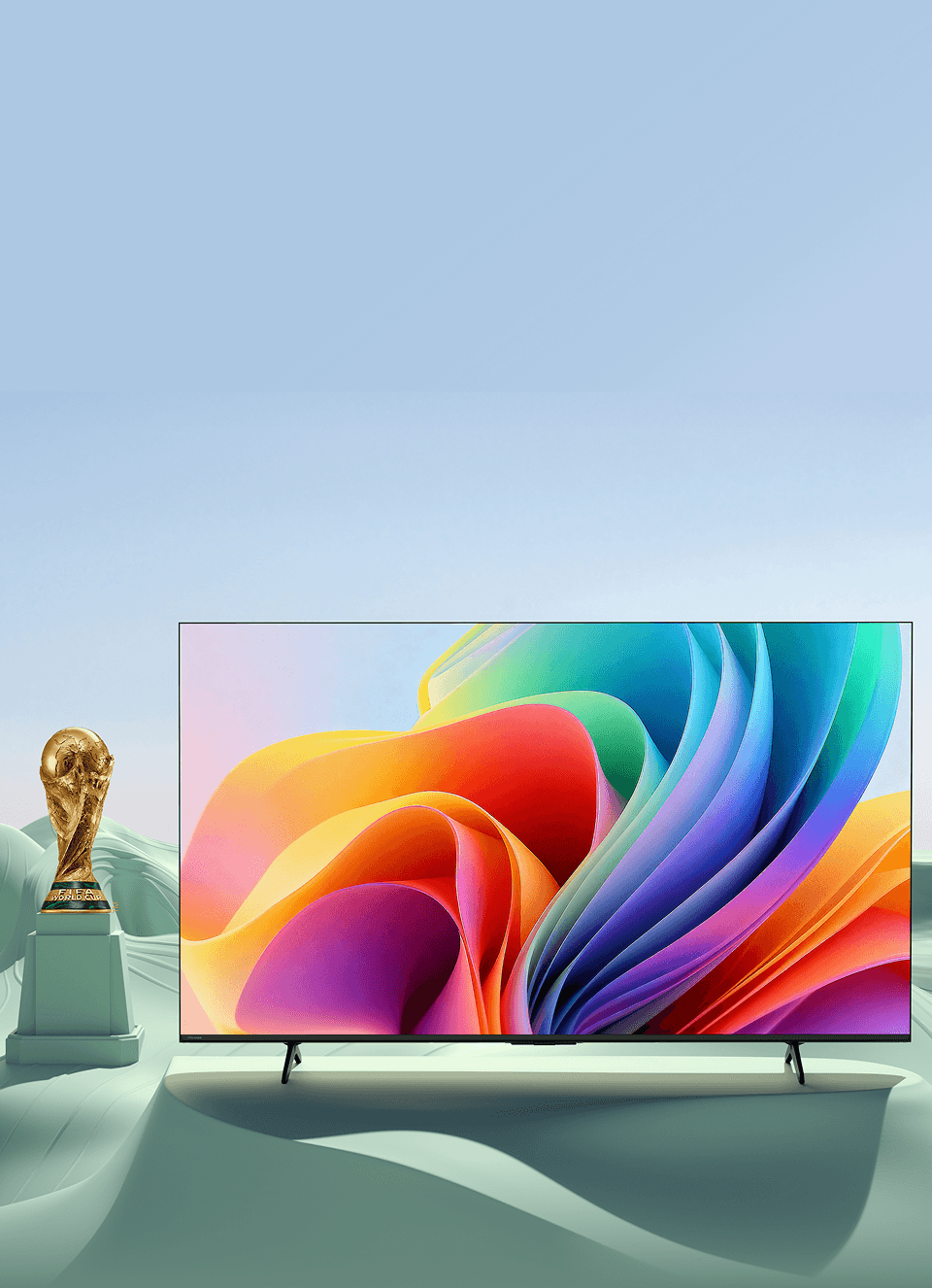 Telewizor z grafiką obok pucharu FIFA (Federation Internationale de Football Association) na tle zielonych wzgórz