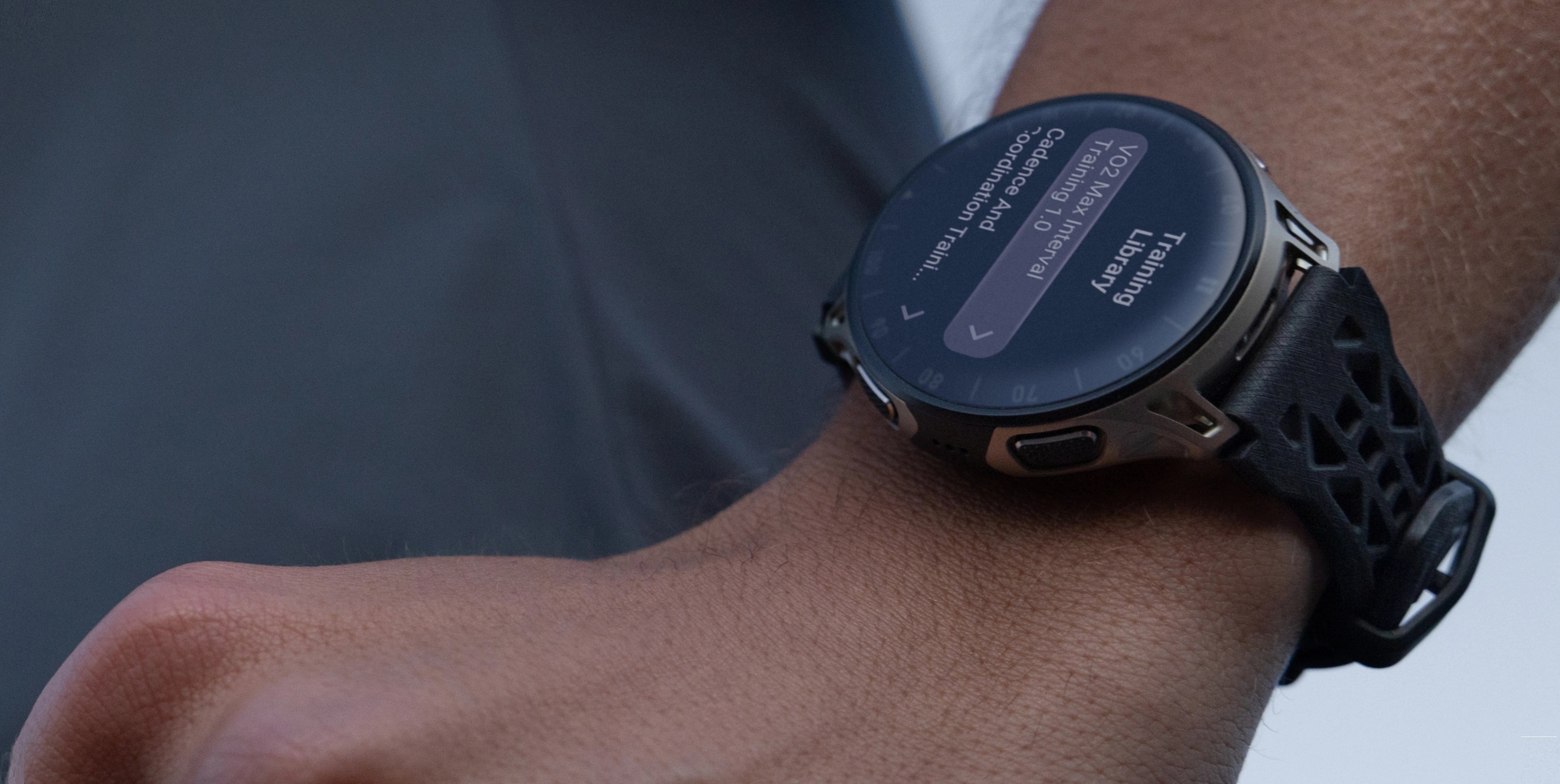 Smartwatch Cheetah 2 Pro na nadgarstku, ekran pokazuje plan treningowy, widoczny sportowy pasek