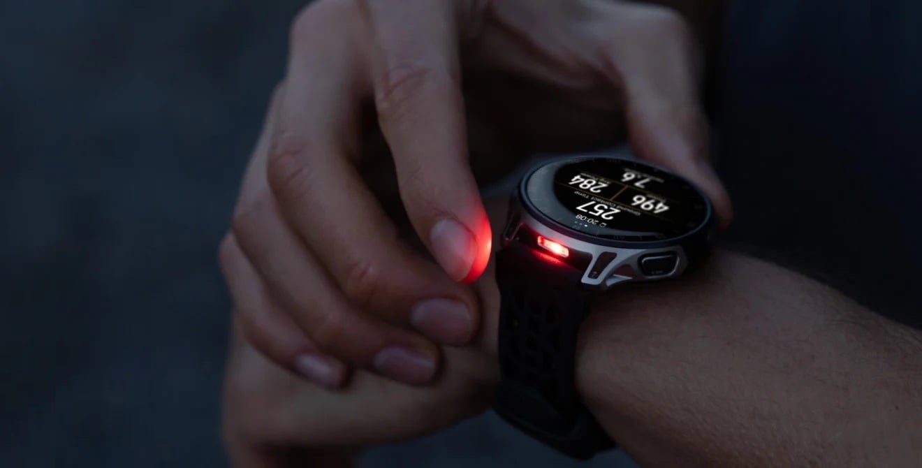 Osoba włącza podświetlenie LED w smartwatchu na nadgarstku, widoczne czerwone światło