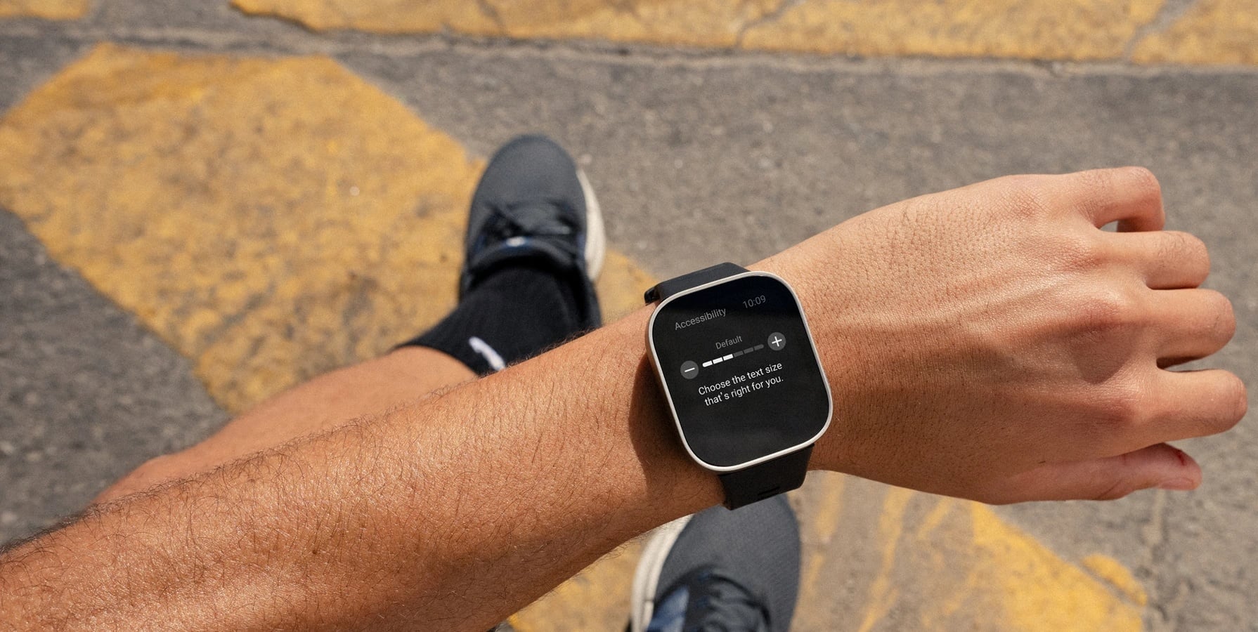 Smartwatch z menu ustawień wielkości tekstu, widoczny na nadgarstku użytkownika.