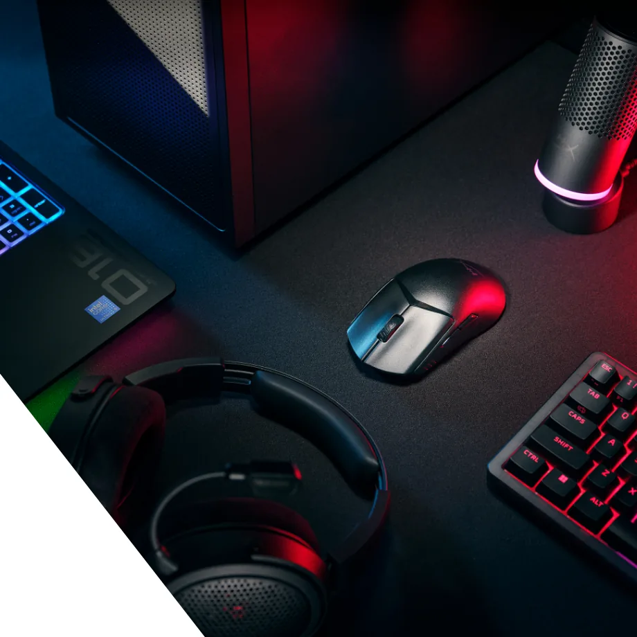 Czarna mysz HyperX na podkładce obok komputera, mikrofonu, słuchawek, laptopa i klawiatury; czerwone i niebieskie światło