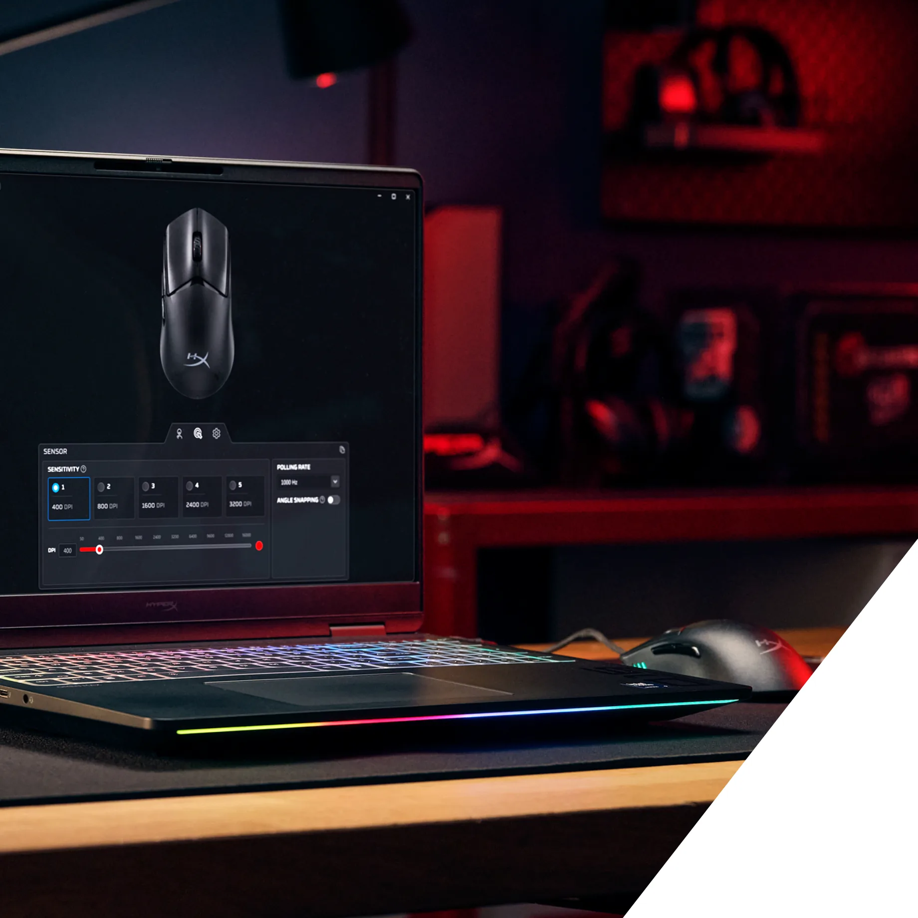 Laptop z panelem ustawień myszy na ekranie i podświetlaną klawiaturą na biurku; po prawej czarna mysz HyperX