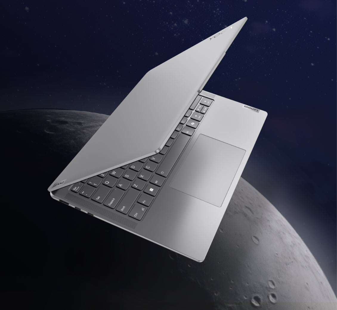 Laptop Yoga Slim 7i w połowie otwarty, widoczny pod kątem, na granatowym tle nieba i elementem graficznym przypominającym księżyc