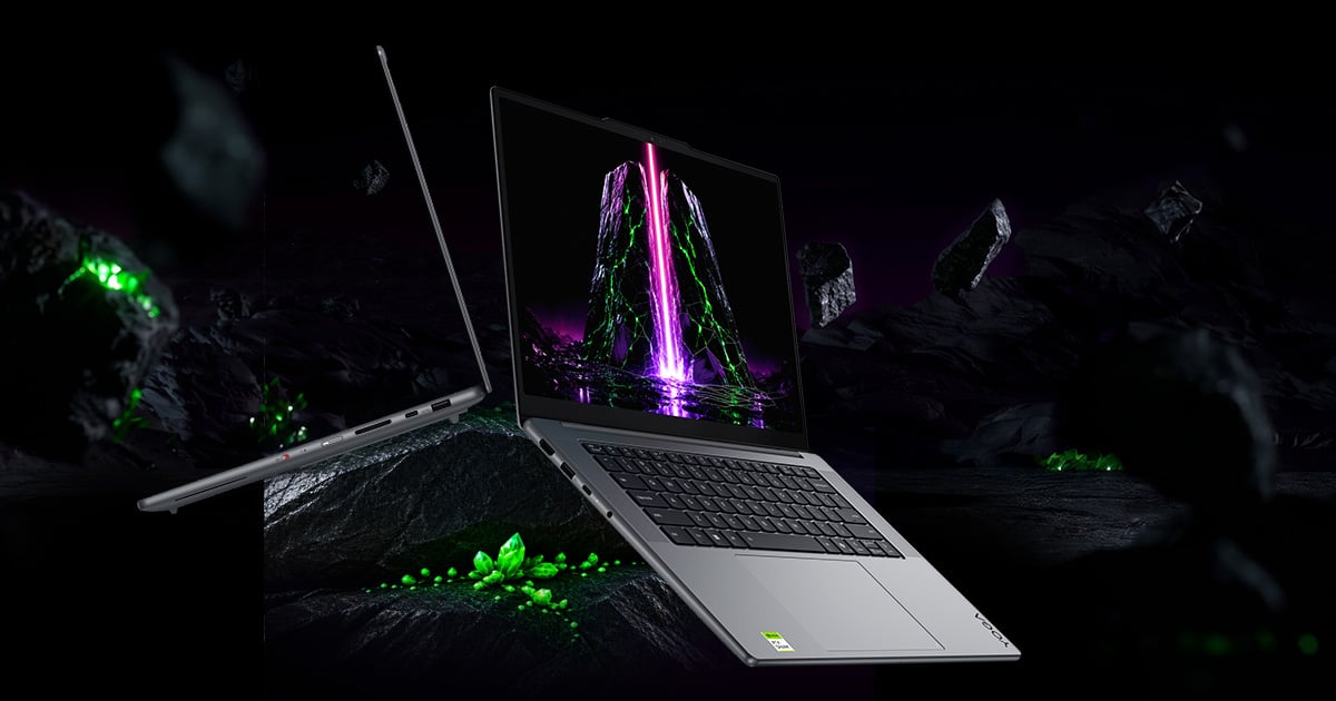 Laptop Lenovo Yoga w ciemnej, abstrakcyjnej scenerii z lewitującymi skałami i zielonymi kryształami.