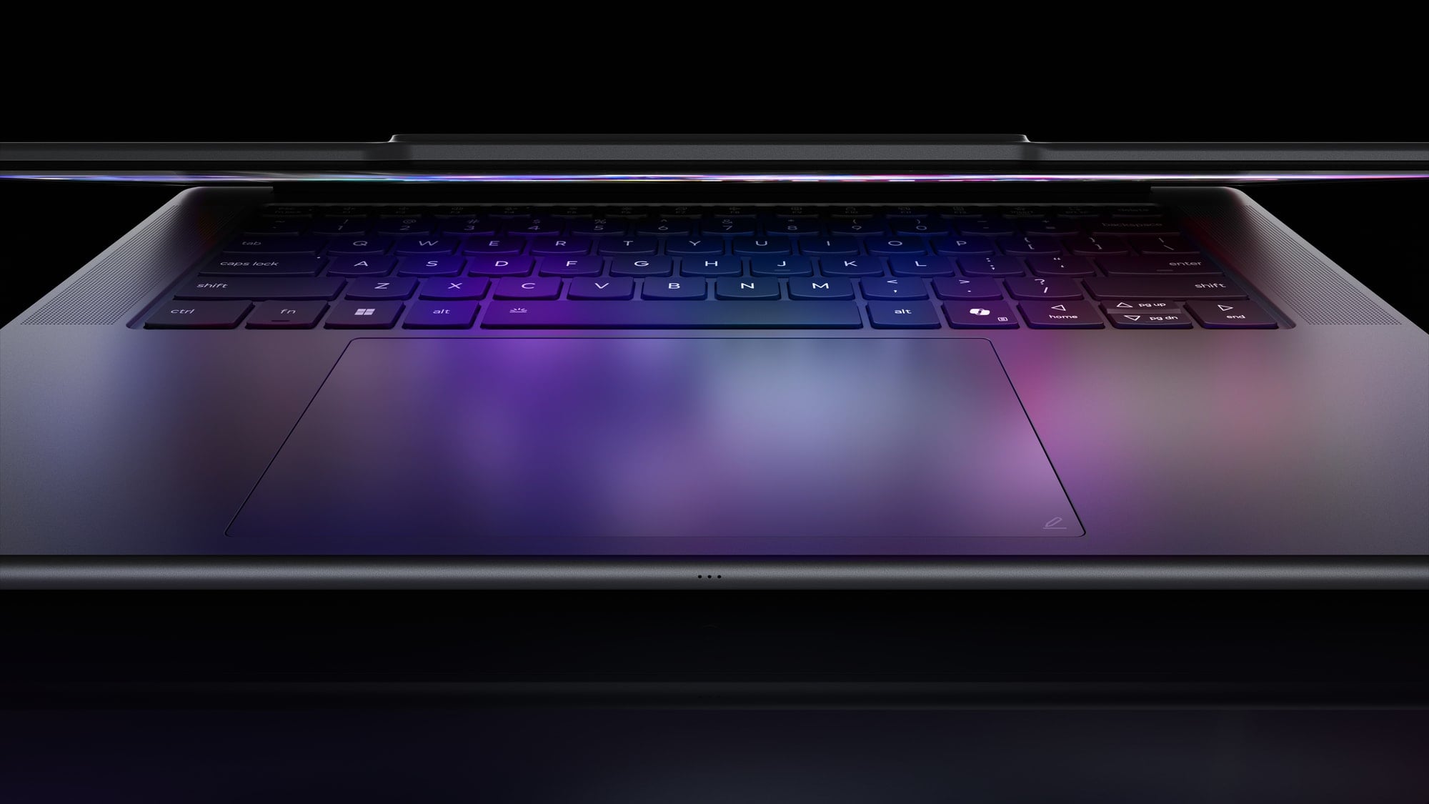 Zbliżenie na klawiaturę i touchpad laptopa z efektownym, fioletowo-niebieskim podświetleniem.