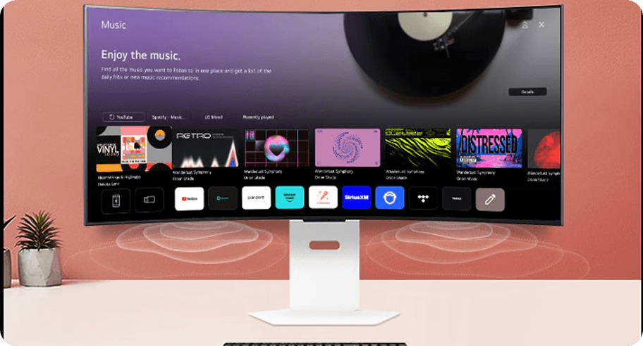 Monitor LG wyświetla sekcję Music z kafelkami albumów. Pod ekranem widoczne białe linie rozchodzącego się dźwięku.
