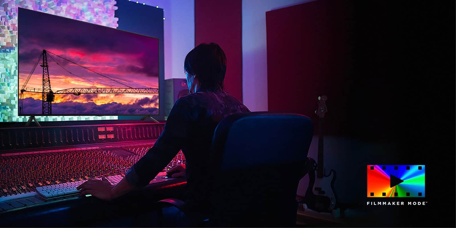 Mężczyzna w ciemnym studiu montażowym patrzy na LG TV wyświetlający zachód słońca. W prawej dolnej części obrazu znajduje się logo FILMMAKER Mode.