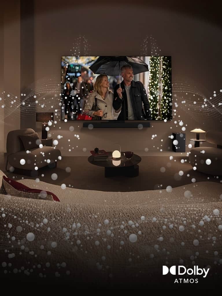 Przytulna, słabo oświetlona przestrzeń mieszkalna, LG OLED TV wyświetlający parę używającą parasola i jasna okrągła grafika otaczająca pokój. Logo Dolby Atoms w lewym dolnym rogu.