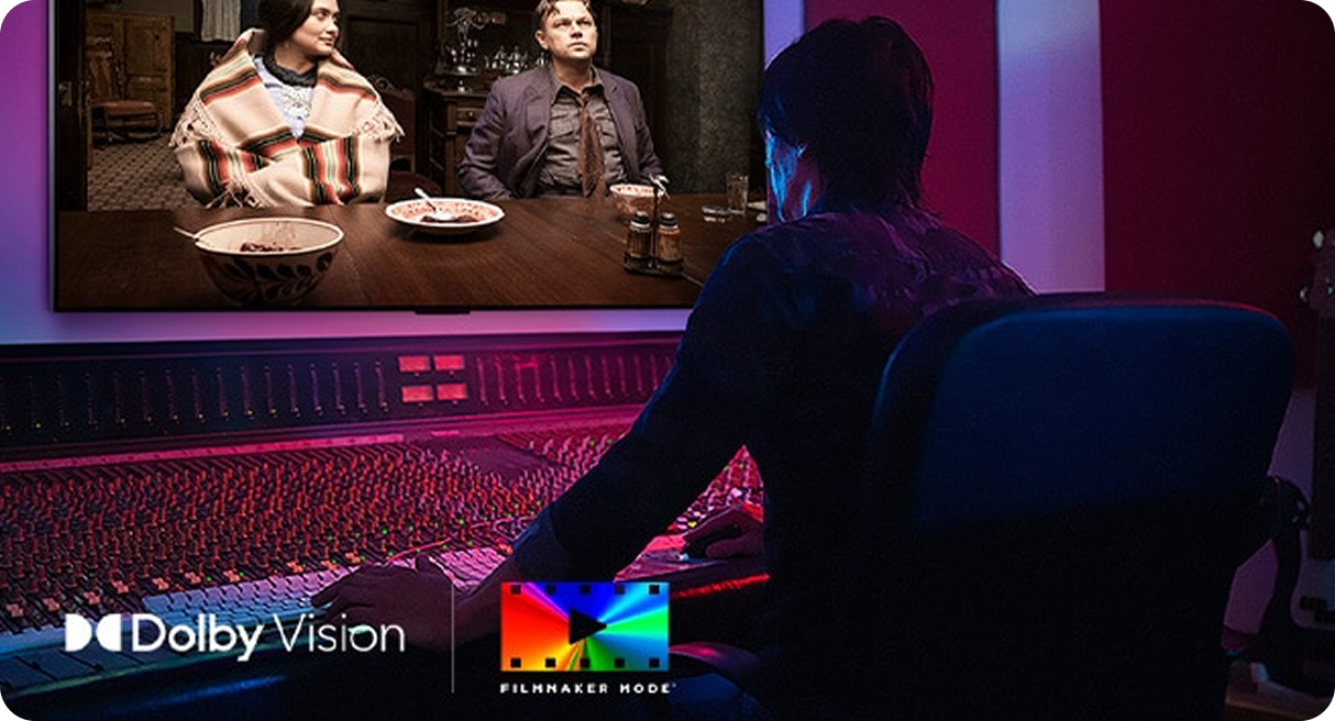 Mężczyzna siedzi w studiu montażowym, przed nim mnóstwo przycisków, a na wprost niego ekran, na którym widać dwoje ludzi