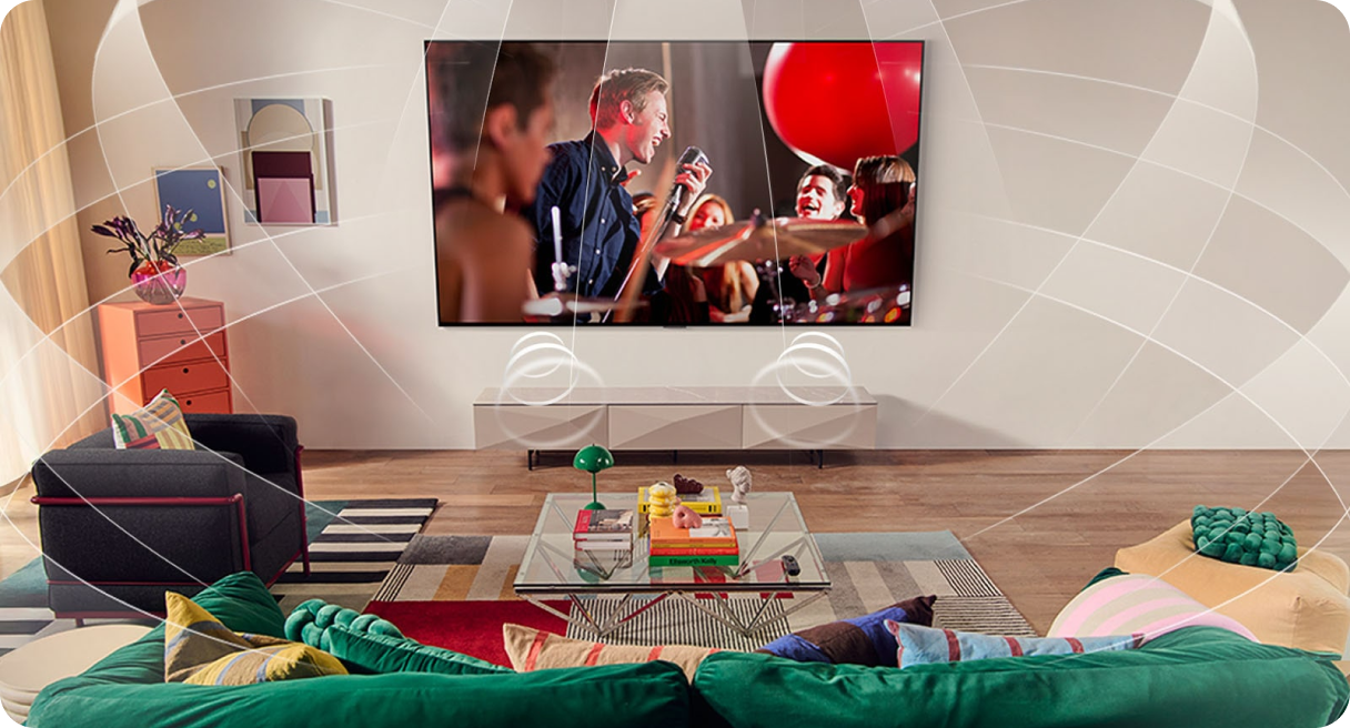 Zawieszony na ścianie w pokoju, duży telewizor z płaskim ekranem, na którym widnieje koncert zespołu muzycznego