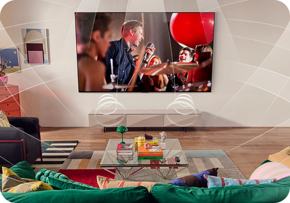 Zawieszony na ścianie w pokoju, duży telewizor z płaskim ekranem, na którym widnieje koncert zespołu muzycznego