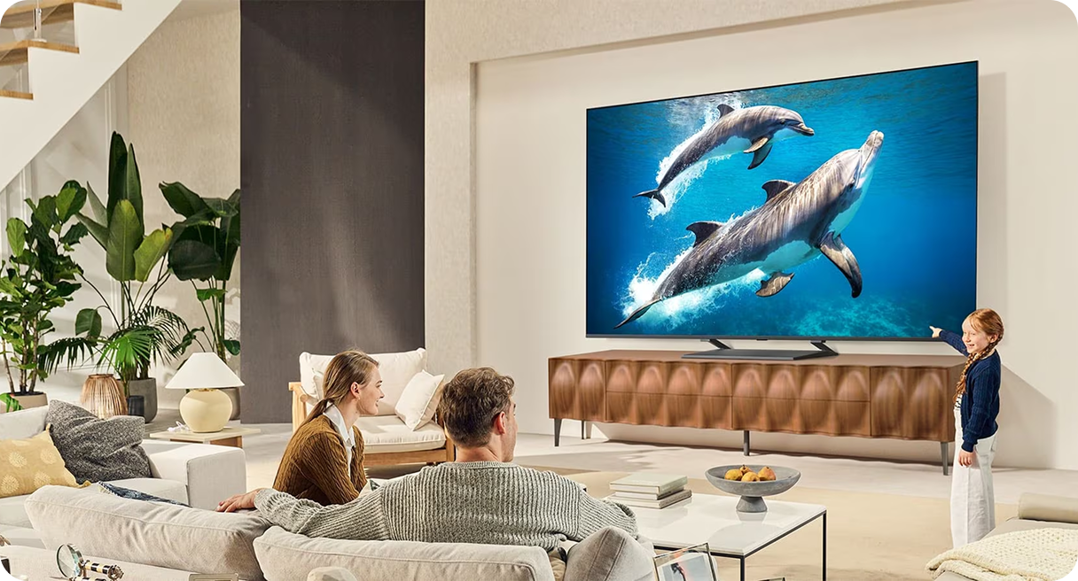 Rodzina w jasnym przestronnym salonie ogląda film przyrodniczy na dużym, płaskim telewizorze ściennym