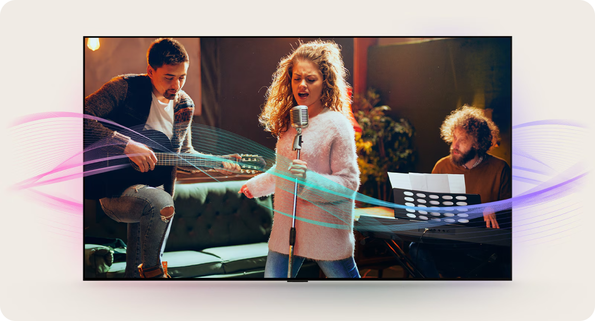 Kobieta w różowym swetrze śpiewa do mikrofonu, po lewej gitarzysta, po prawej mężczyzna gra na organach