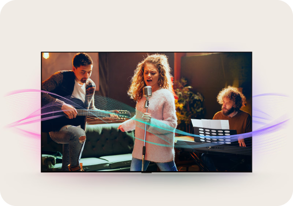 Kobieta w różowym swetrze śpiewa do mikrofonu, po lewej gitarzysta, po prawej mężczyzna gra na organach