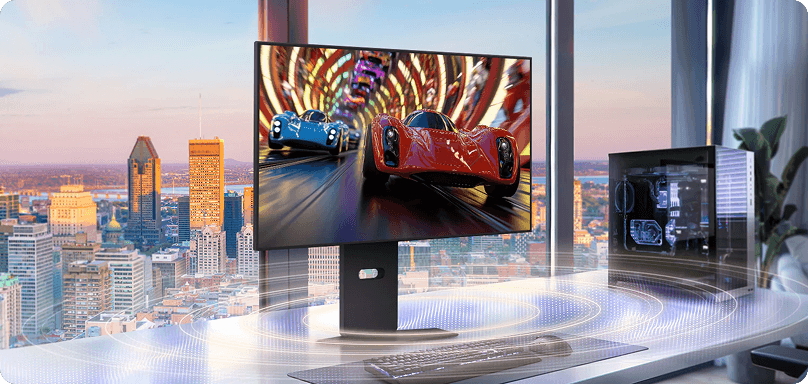 Monitor LG na biurku z widokiem na miasto, prezentujący grę wyścigową oraz efekt dźwięku przestrzennego na blacie