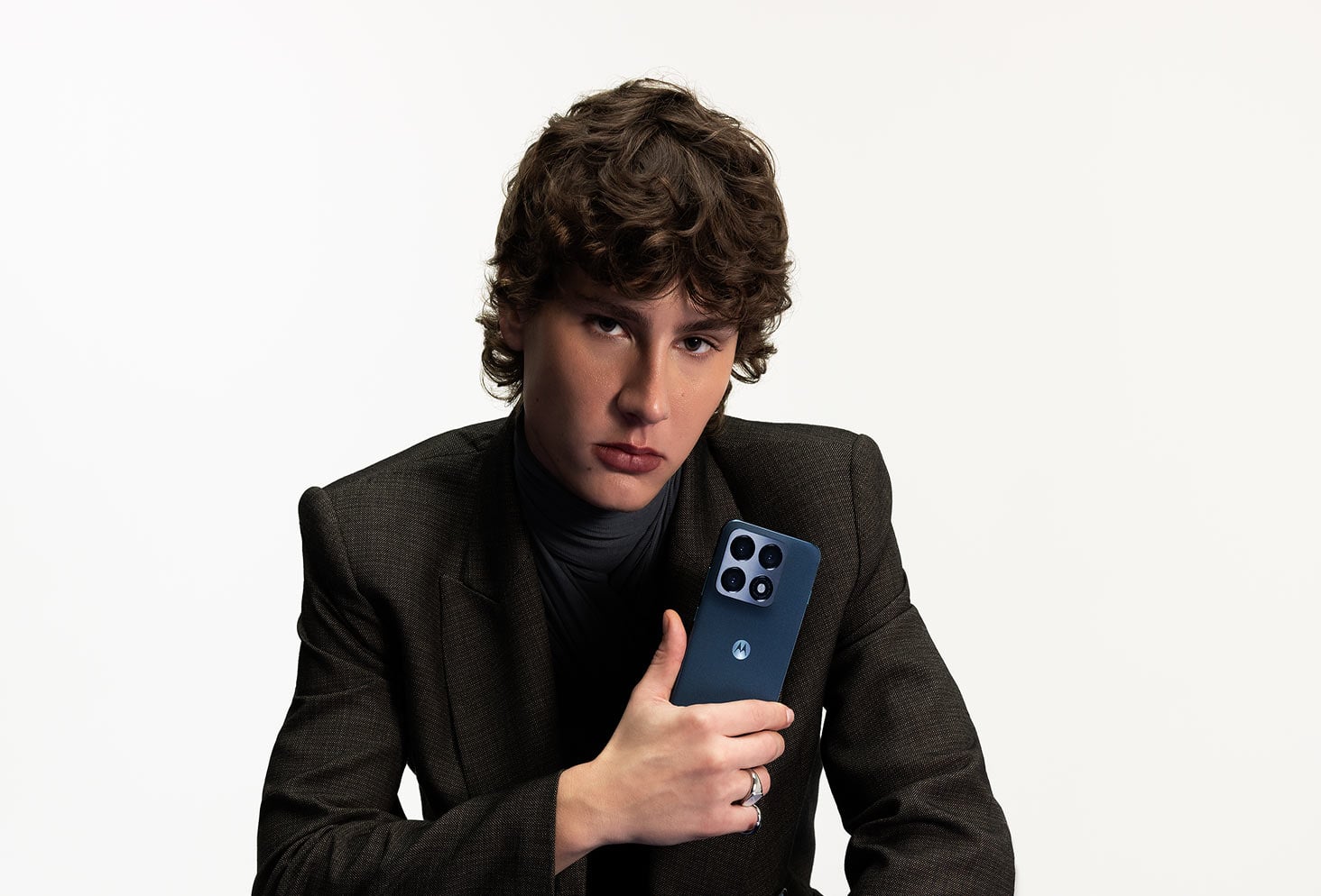 Mężczyzna w marynarce prezentujący granatowy smartfon.