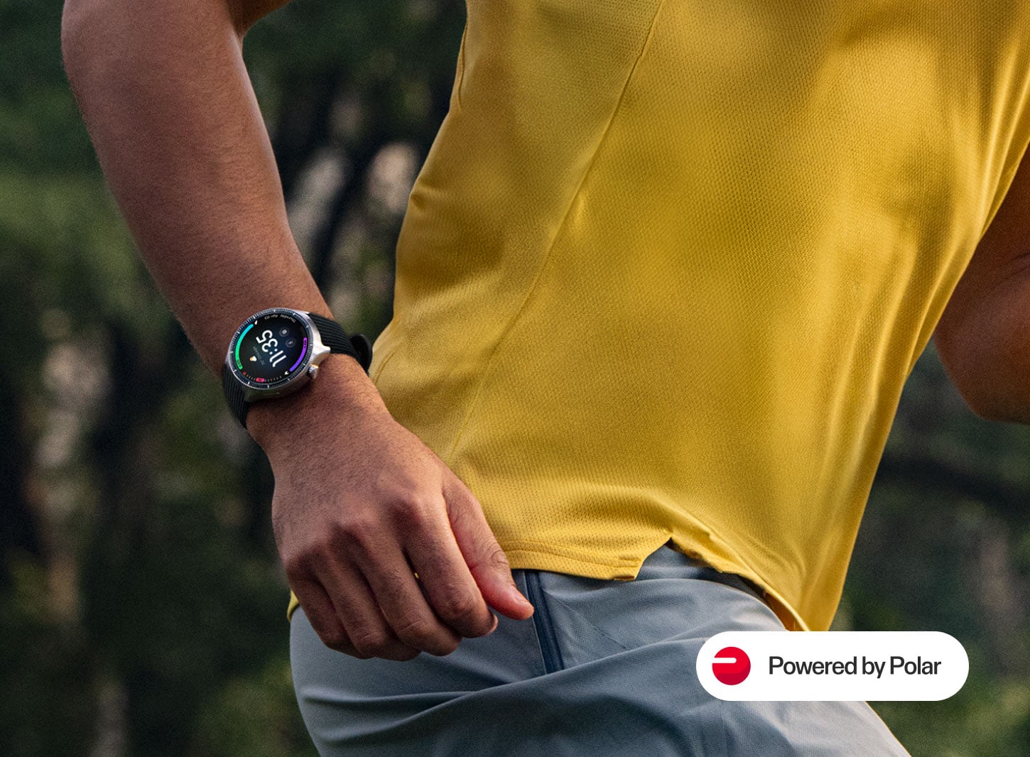 Mężczyzna w żółtej koszulce biegowej z czarnym smartwatchem moto watch ultra na nadgarstku