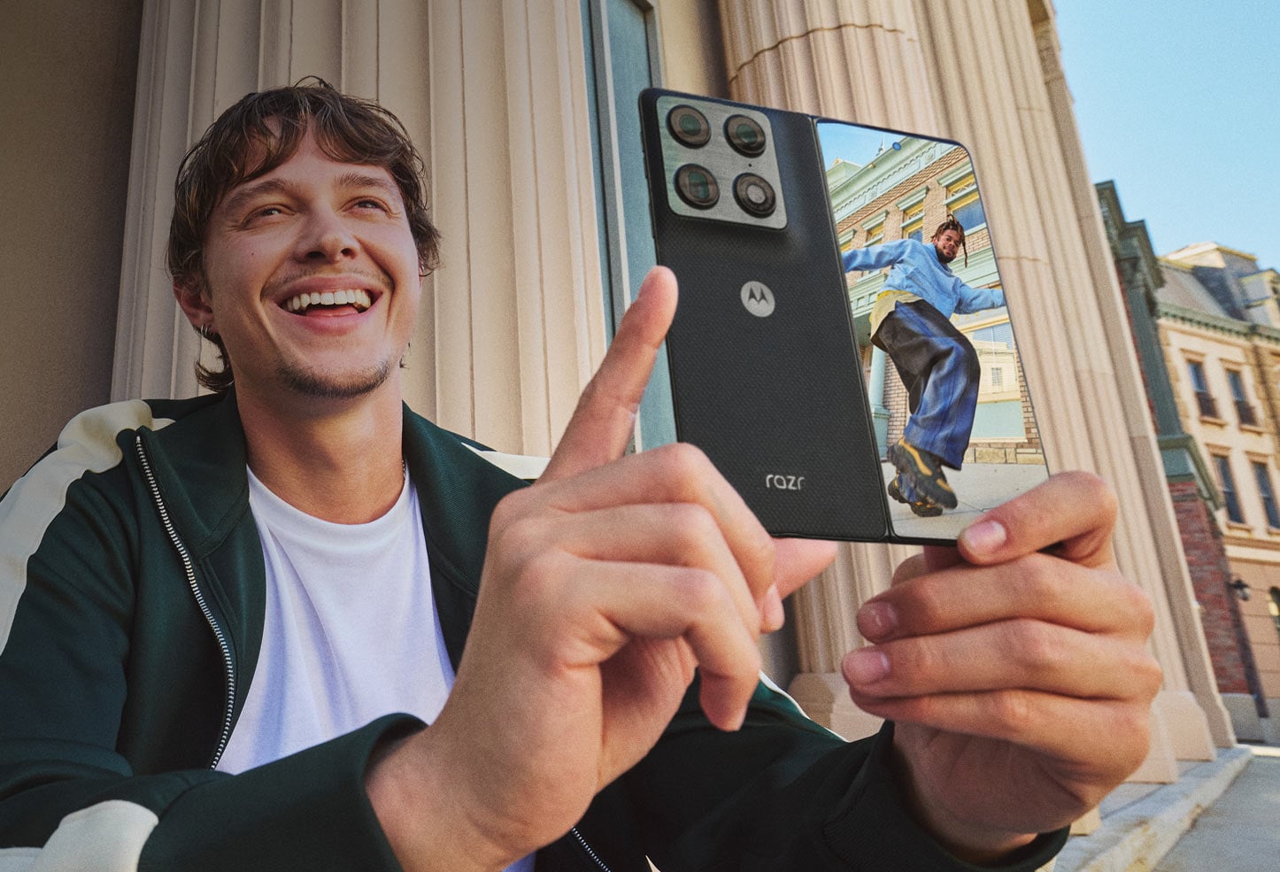 Uśmiechnięty mężczyzna robiący dynamiczne zdjęcie rozłożonym smartfonem razr fold