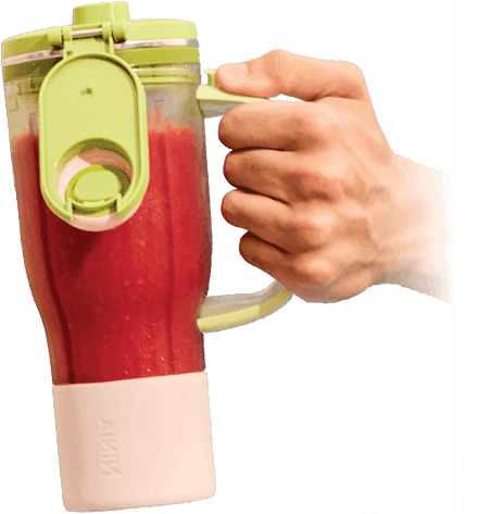 Męska ręka trzymająca za rączkę zielono-biały bidon BlendBoss wypełniony czerwonym smoothie