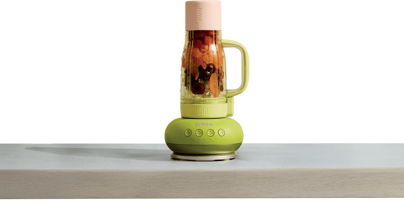 Zielono-różowy blender Ninja BlendBoss wypełniony owocami, stojący na jasnym blacie