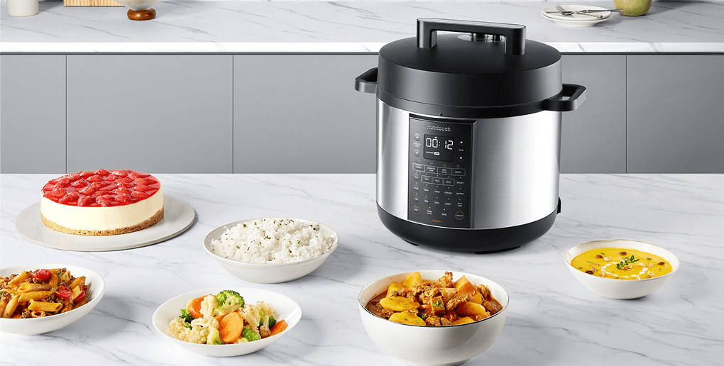 Srebrno-czarny multicooker z wyświetlaczem LCD (Liquid Crystal Display), otoczony miskami z ryżem, gulaszem i zupą