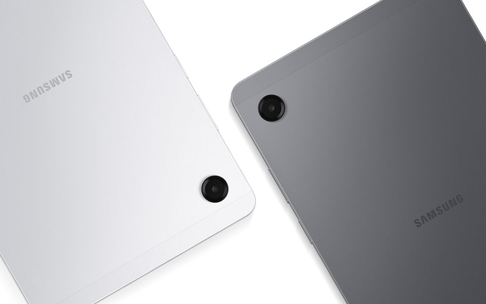 Dwa tablety Galaxy Tab A11, jeden szary, a drugi srebrny, ustawione są obok siebie, tyłem do użytkownika. Widoczne są obiektywy tylnych aparatów obu tabletów.