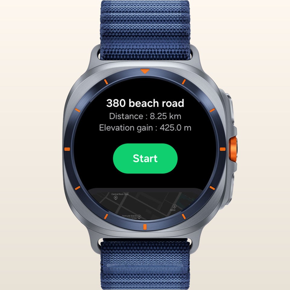 Galaxy Watch Ultra wyświetla ekran funkcji trasy z miejscem docelowym, przewyższeniami odległości i przyciskiem „Start”. Galaxy Watch Ultra wyświetla ekran funkcji trasy z miejscem docelowym, przewyższeniami odległości i przyciskiem „Start”.