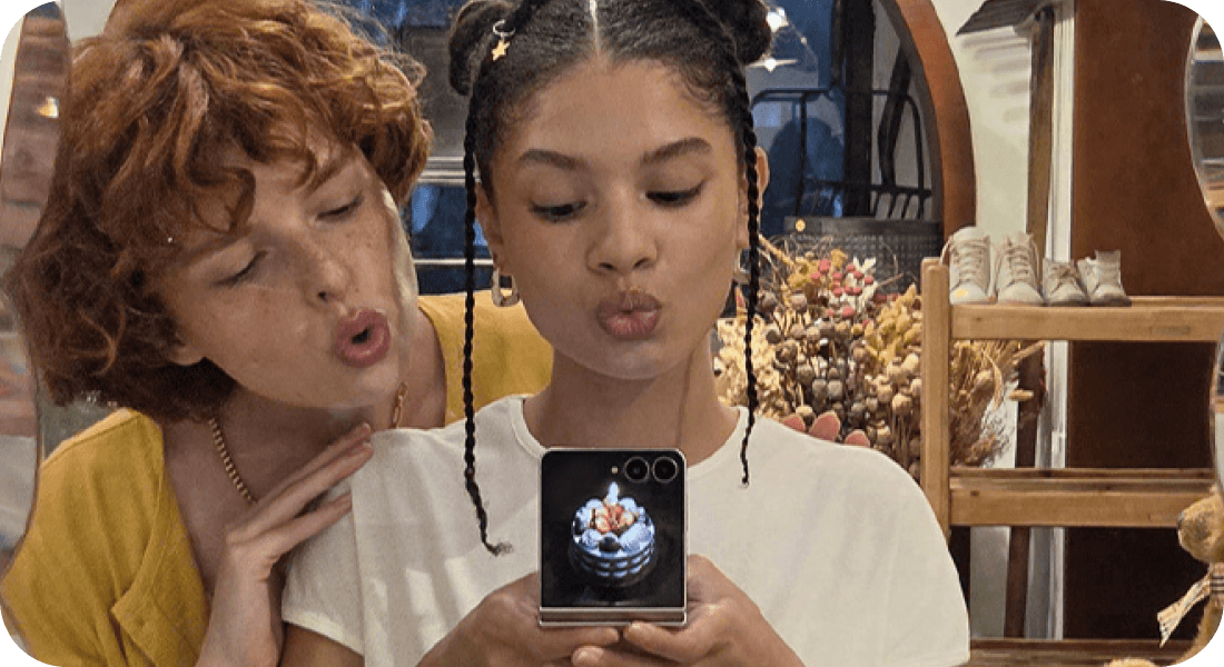 Dwie osoby robią selfie Galaxy Z Flip8, a na ekranie zewnętrznym widać tort.