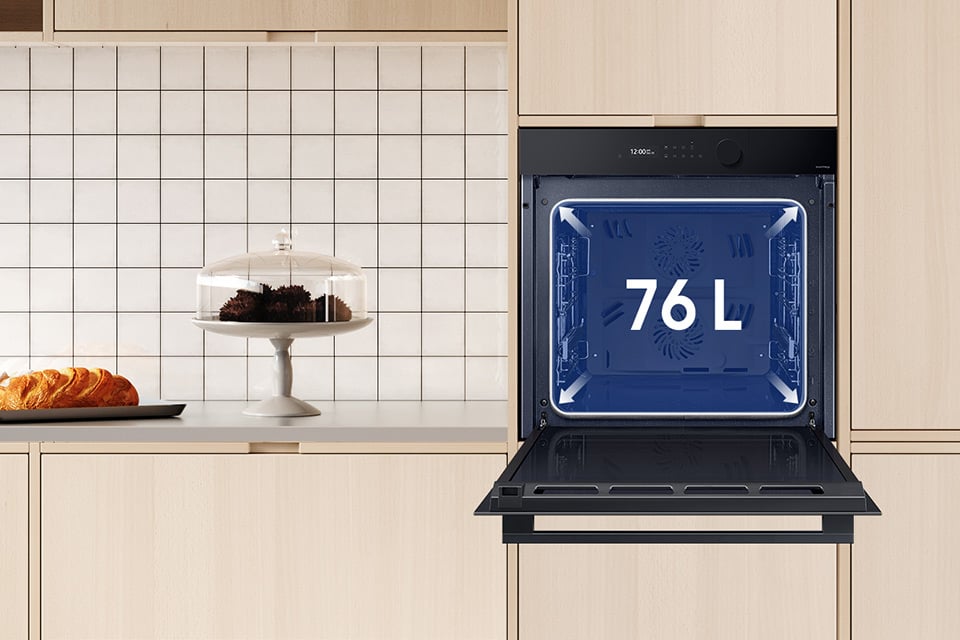 Na zdjęciu pokazano piekarnik Samsung NV7B5660RAK/U2 w jasnej zabudowie kuchennej, wraz z informacją o pojemności wynoszącej 76 litrów
