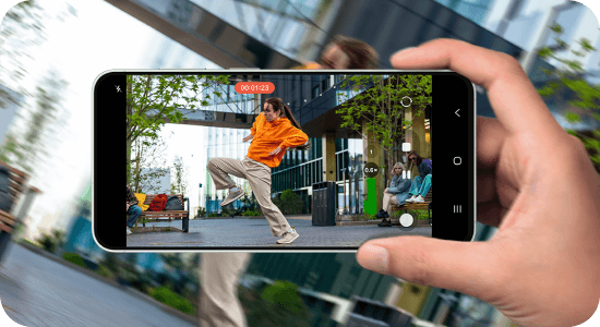 Dłoń nagrywa tańczącą osobę smartfonem Galaxy, prezentując stabilizację obrazu w ruchu.