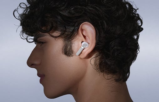 Osoba nosząca słuchawki Galaxy Buds4 Pro, patrząca w lewo.